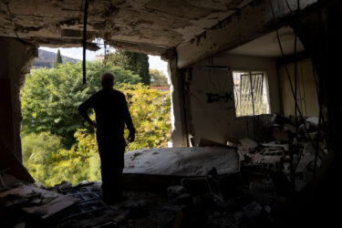 KIRYAT SHMONA, ISRAEL - NOVEMBER 20: Izhak Moyal, a neighbour, inspects a damaged apartment after a rocket strike from Lebanon against the northern city on 20/11/2024 in Kiryat Shmona, Israel. Israeli Army Radio reported that a rocket fired from Lebanon crashed into the building this morning. (Photo by Amir Levy/Getty Images)