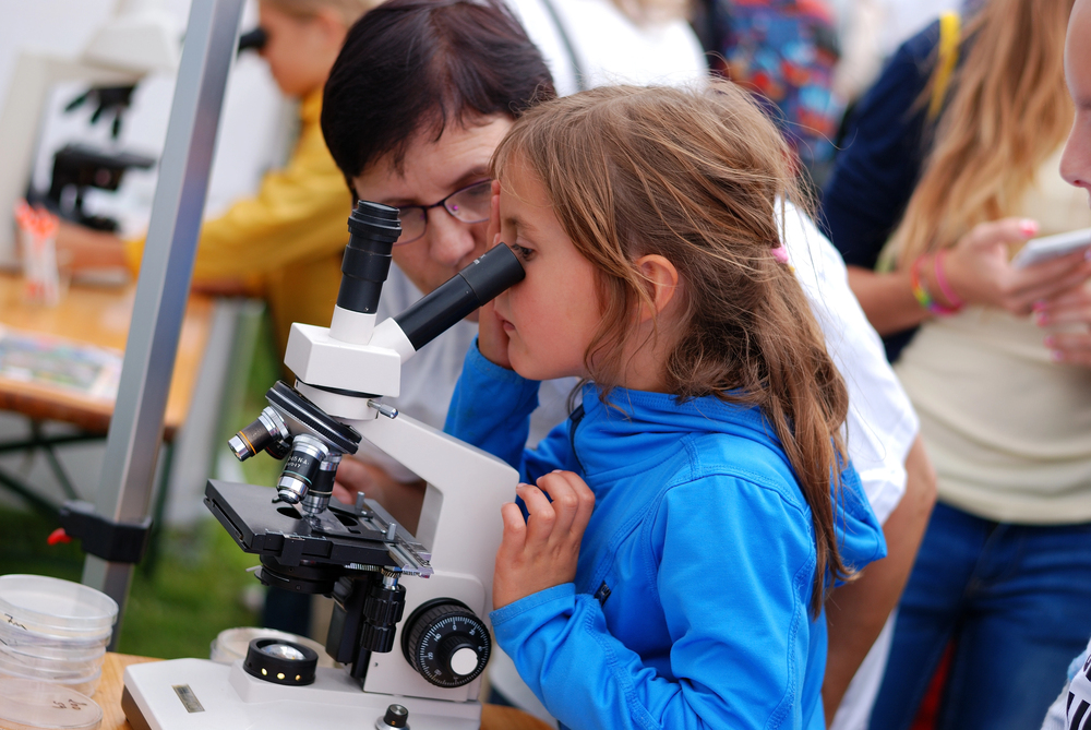 Girl Looks through the Microscope